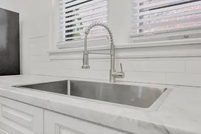 a stainless steel sink in a white kitchen at Updated 4BD House Near German Village w Parking in Columbus