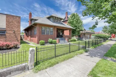 a brick house with a fence in front of it at Updated 4BD House Near German Village w Parking in Columbus