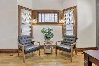 two chairs and a table in a room with windows at Updated 4BD House Near German Village w Parking in Columbus