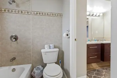 a bathroom with a toilet and a tub and a sink at Housepitality - The Woodward Park Charmer - 4BR in Columbus