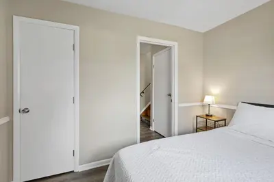 a bedroom with a white bed and a closet at Housepitality - The Woodward Park Charmer - 4BR in Columbus