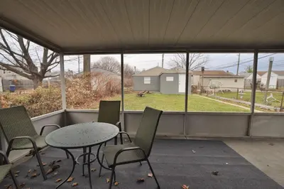 a screened in porch with a table and chairs at Housepitality - The Southern Orchards Cottage in Columbus