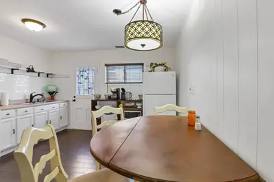 a kitchen with a wooden table and chairs at Housepitality - The Southern Orchards Cottage in Columbus