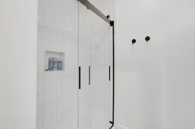 a shower with a glass door in a bathroom at Housepitality - The Brandenburg Suite - Efficiency in Columbus