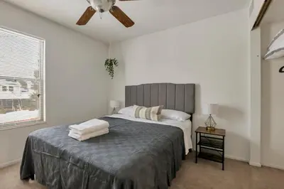 a bedroom with a bed with a ceiling fan at Housepitality - The Gahanna Hideaway in Gahanna
