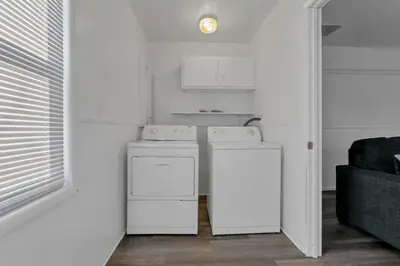 a kitchen with two washer and dryers in a room at Housepitality - West Side Lodge - 6 BR 2 BA in Columbus