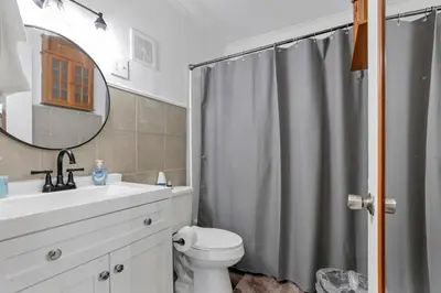 a bathroom with a shower curtain and a toilet at Housepitality - West Side Lodge - 6 BR 2 BA in Columbus