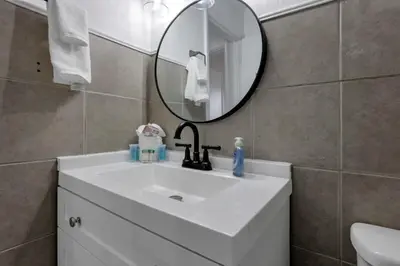 a bathroom with a white sink and a mirror at Housepitality - West Side Lodge - 6 BR 2 BA in Columbus