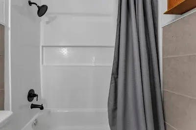 a bathroom with a shower with a shower curtain at Housepitality - West Side Lodge - 6 BR 2 BA in Columbus