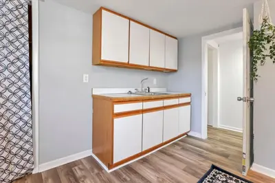 a kitchen with white cabinets and a sink at Housepitality - West Side Lodge - 6 BR 2 BA in Columbus