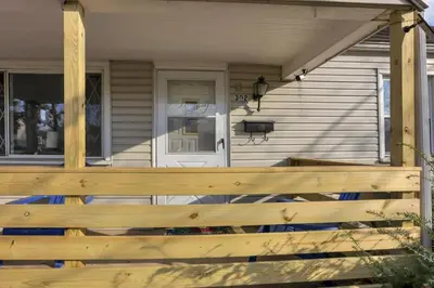 a porch with a wooden fence in front of a house at Housepitality - West Side Lodge - 6 BR 2 BA in Columbus
