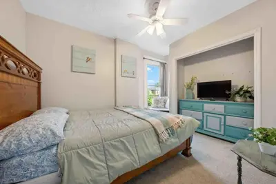 a bedroom with a bed with a ceiling fan and a television at The Village Townhouse - 5 BR in Columbus