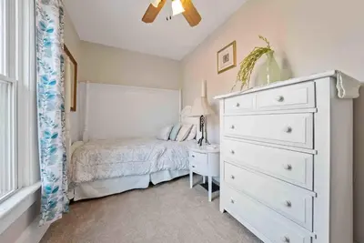 a bedroom with a white dresser and a bed with a night stand at The Village Townhouse - 5 BR in Columbus