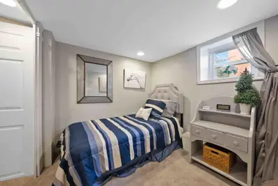 a small bedroom with a bed and a mirror at The Village Townhouse - 5 BR in Columbus