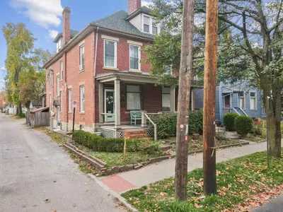 a red brick house with a porch on a street at The Village Townhouse - 5 BR in Columbus