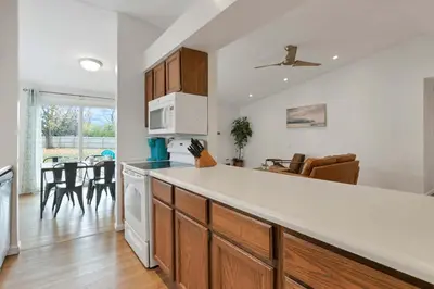 a kitchen with a white counter top and a living room at The Spacious Hilliard House in Columbus