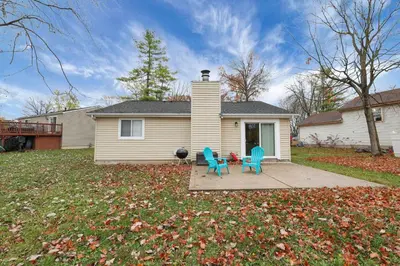 a house with two chairs and a table in the yard at The Spacious Hilliard House in Columbus