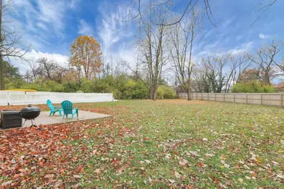 two blue chairs and a grill in a yard at The Spacious Hilliard House in Columbus