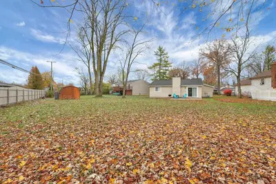 a yard with leaves on the ground in front of a house at The Spacious Hilliard House in Columbus