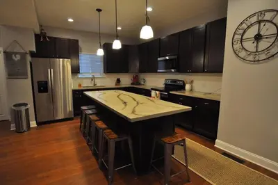 a kitchen with a large island in the middle at Housepitality - Franklinton Farmhouse- 4 Bedrooms in Columbus