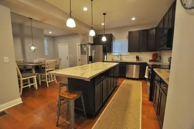 a kitchen with a large island in the middle at Housepitality - Franklinton Farmhouse- 4 Bedrooms in Columbus