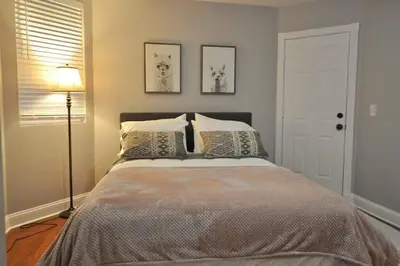 a bedroom with a large bed with pillows and a lamp at Housepitality - Franklinton Farmhouse- 4 Bedrooms in Columbus