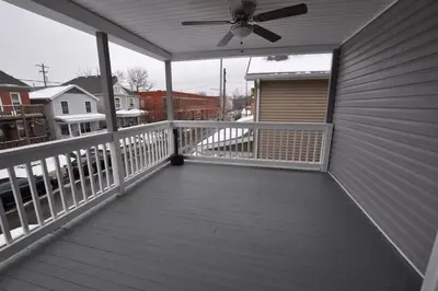 a porch with a ceiling fan on a house at Housepitality - Franklinton Farmhouse- 4 Bedrooms in Columbus