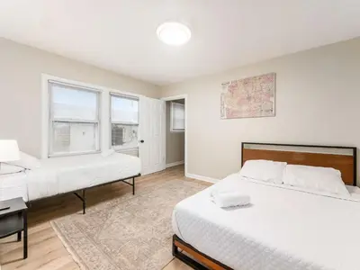 a bedroom with two beds and a desk and windows at Stay in the Palazzo in OSU! 10 BEDS! in Columbus