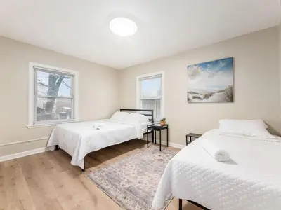 two beds in a room with two windows at Stay in the Palazzo in OSU! 10 BEDS! in Columbus