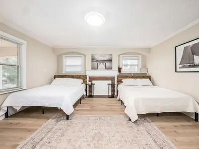 a room with three beds and a fireplace at Stay in the Palazzo in OSU! 10 BEDS! in Columbus
