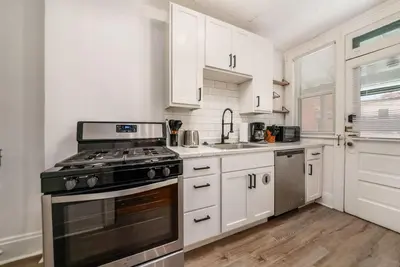 a kitchen with white cabinets and a stove top oven at The Cobblestone Townhouse - 2 BR -German Village in Columbus