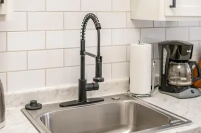 a kitchen sink with a faucet on top of it at The Cobblestone Townhouse - 2 BR -German Village in Columbus