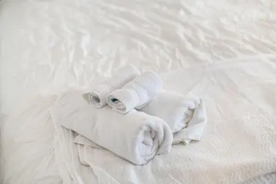 a pile of towels sitting on top of a bed at The Cobblestone Townhouse - 2 BR -German Village in Columbus