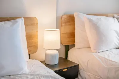 a bedroom with two beds and a lamp on a night stand at The Cobblestone Townhouse - 2 BR -German Village in Columbus