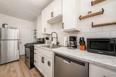 a kitchen with white cabinets and a stainless steel appliances at The Cobblestone Townhouse - 2 BR -German Village in Columbus