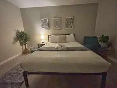 a bedroom with a large bed and a blue chair at Housepitality - The Gahanna Ranch - 3 BR - Airport in Gahanna