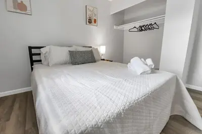 a bedroom with a white bed with a white comforter at Housepitality - The Gahanna Ranch - 3 BR - Airport in Gahanna