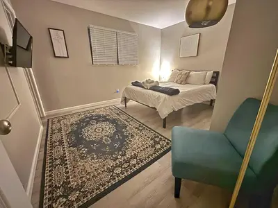 a small bedroom with a bed and a blue chair at Housepitality - The Gahanna Ranch - 3 BR - Airport in Gahanna