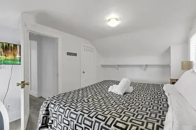 a bedroom with a bed with a black and white comforter at Housepitality - The Marienplatz - Free Parking in Columbus