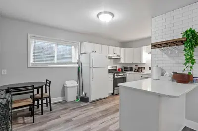 a kitchen with a white refrigerator and a table at German Village Hidden Gem - 3 BR, Parking l Value in Columbus