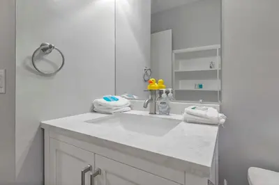 a white bathroom with a sink and a mirror at German Village Hidden Gem - 3 BR, Parking l Value in Columbus