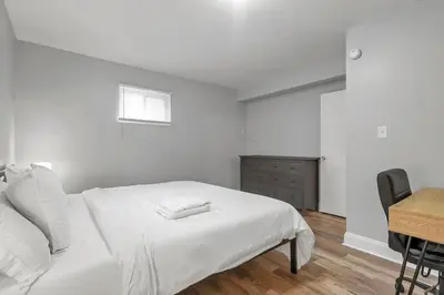 a white bedroom with a bed and a desk at German Village Hidden Gem - 3 BR, Parking l Value in Columbus