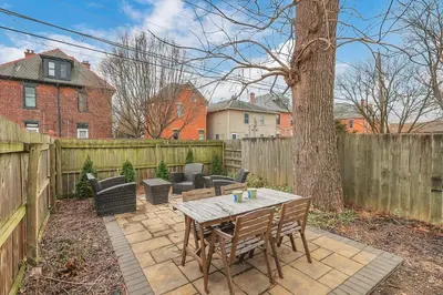 a backyard with a wooden table and a wooden fence at German Village Hidden Gem - 3 BR, Parking l Value in Columbus