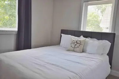 a bed with white sheets and pillows in a bedroom at Housepitality - Top Choice Flat - Location in Columbus