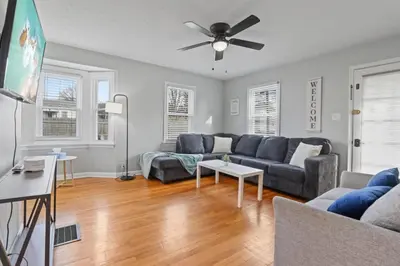 a living room with a couch and a ceiling fan at Housepitality - Newark Friends and Family House in Newark