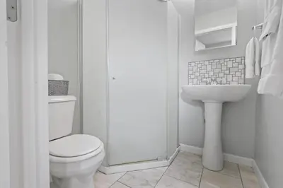 a white bathroom with a toilet and a sink at Housepitality - Newark Friends and Family House in Newark