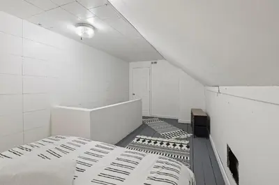 a white room with two beds and a table at Housepitality - City View Loft - German Village in Columbus