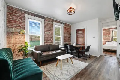 a living room with a couch and a brick wall at Housepitality - City View Loft - German Village in Columbus