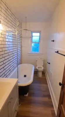 a white bathroom with a tub and a toilet at Housepitality - Cityscape - Historic 2BR in Columbus