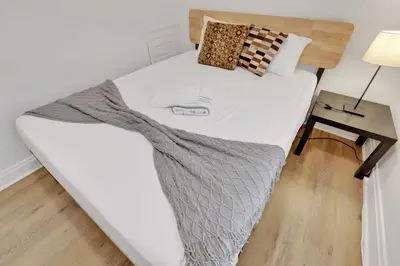 a large white bed in a room with a table at Housepitality- The 614 Peaceful Escape - Old Town in Columbus